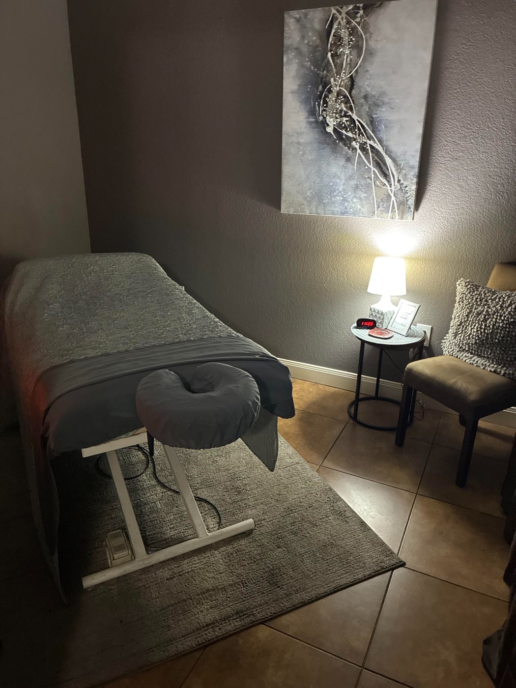 FlowTherapy treatment room with a prepared massage table and a warm bedside lamp